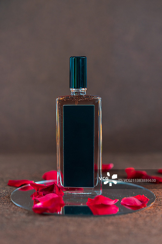 镜子上的香水瓶和散落的玫瑰花瓣图片素材