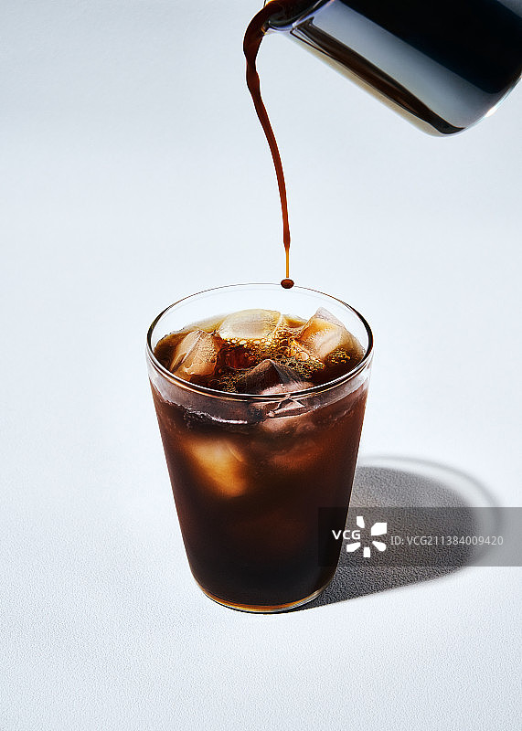 一杯冰美式咖啡倒入玻璃杯图片素材