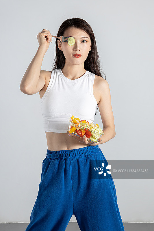 吃蔬菜沙拉的运动系健康美女图片素材