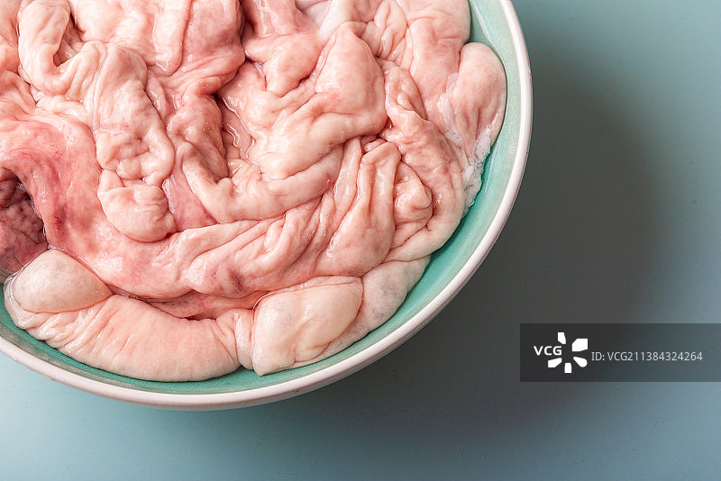 青底桌面上一碗新鲜洗干净的猪大肠图片素材