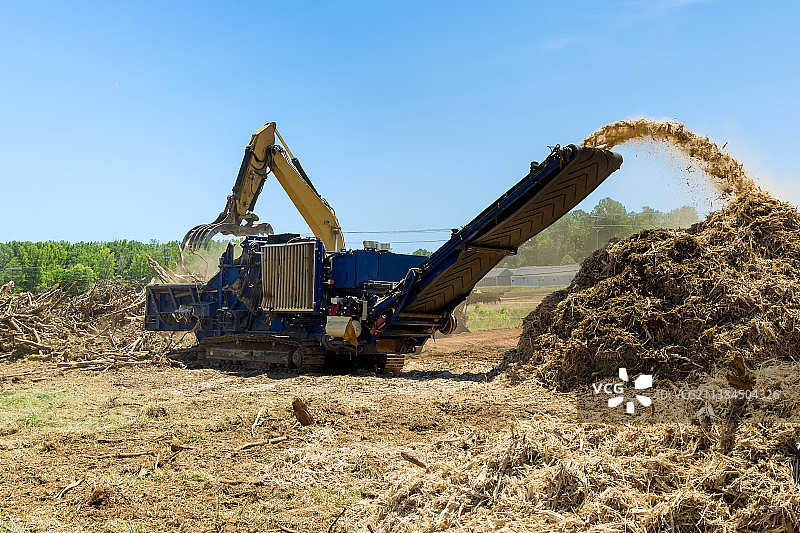 液压起重机在根木中为粉碎机装载图片素材