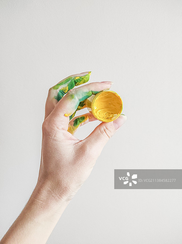 裁剪的手在白色背景前拿着油漆图片素材