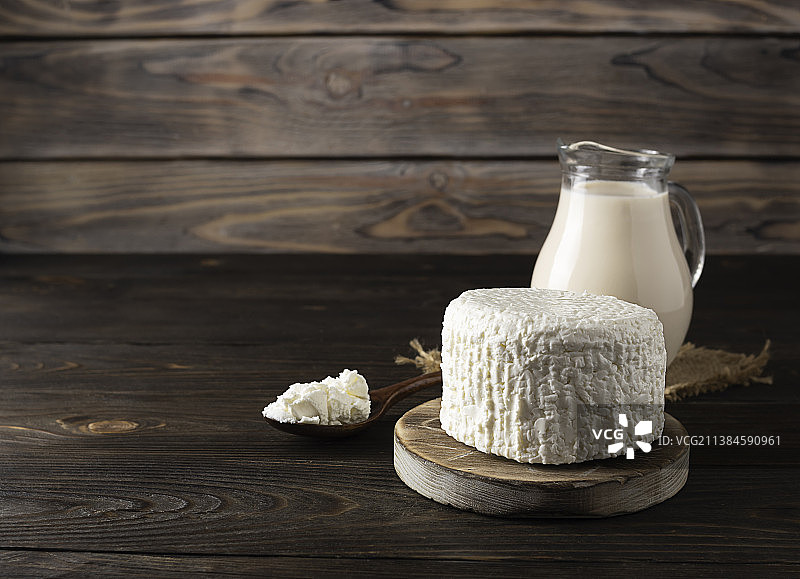 圆形木板上的新鲜牛奶和农家奶酪图片素材