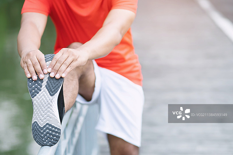 男人锻炼和健康概念，男人站在路上系鞋带的下半身图片素材