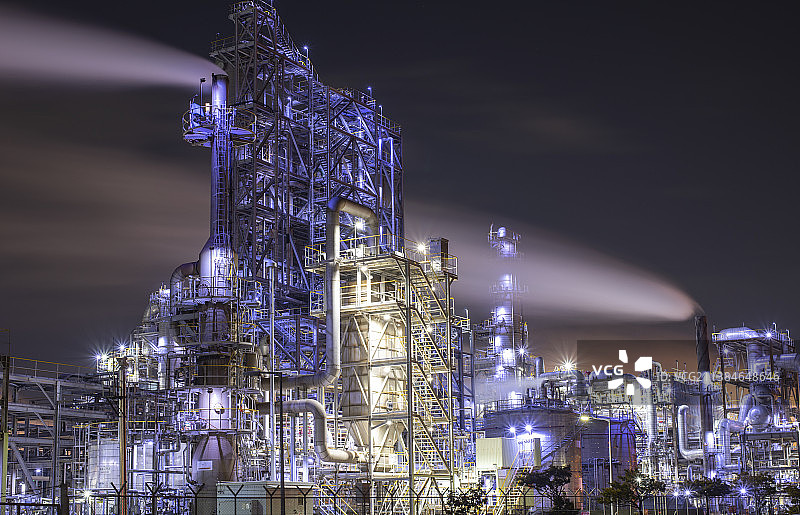 夜间天空下的灯光工厂低角度视图图片素材