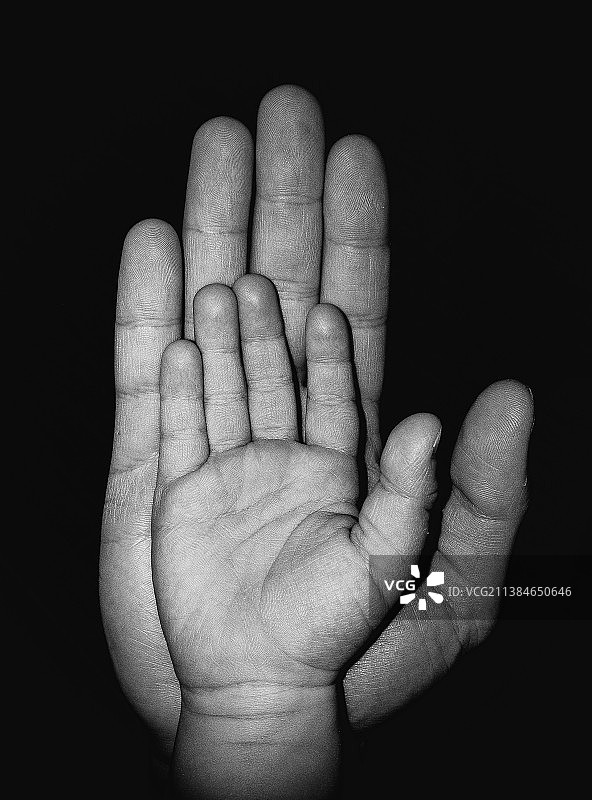 父亲和儿子，黑色背景下的人手特写图片素材