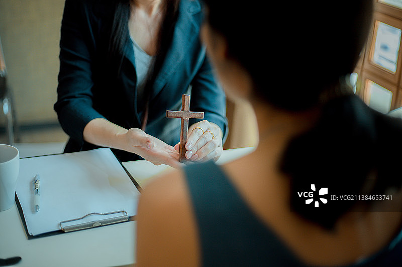 共同奉献十字架木材的基督教徒之手图片素材