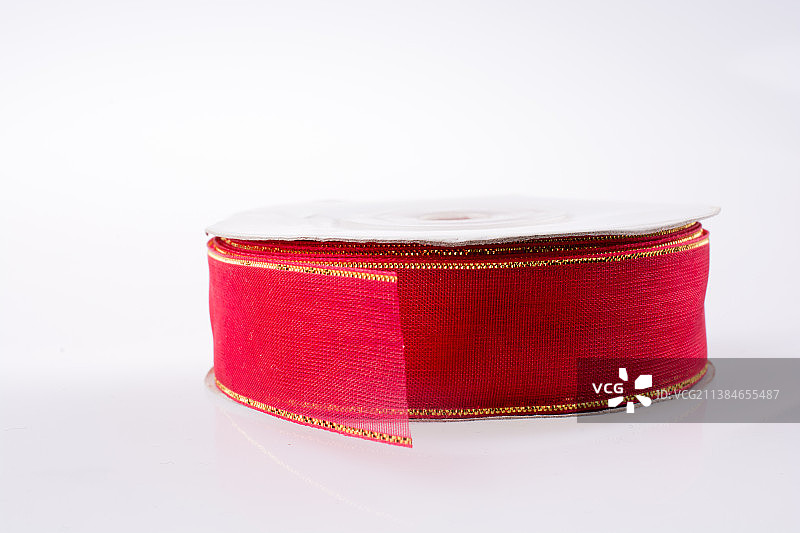 一卷红色丝带，白色背景上的红色钱包特写图片素材