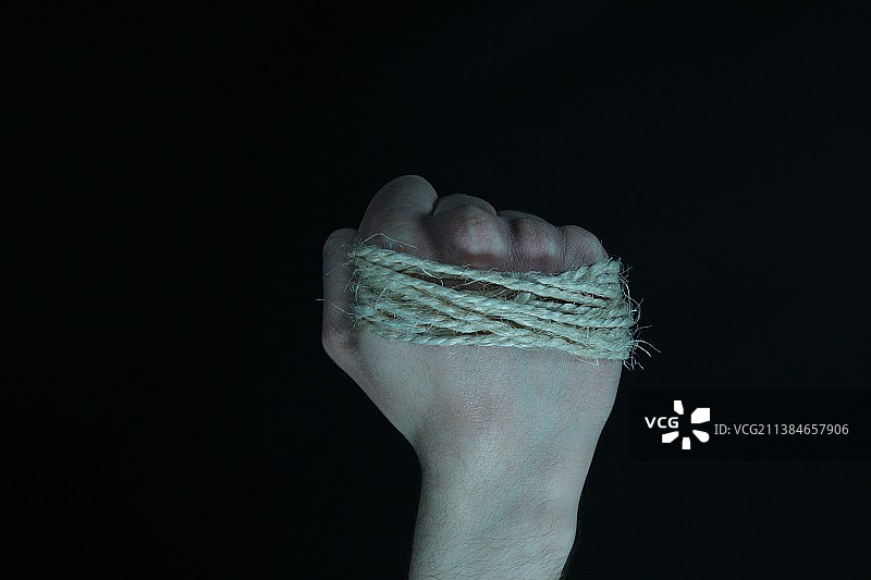 紧紧缠绕在紧握拳头上的绳子图片素材