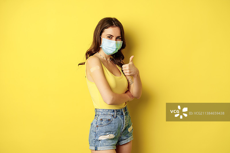 年轻女子在灰色背景前手持书本的肖像图片素材