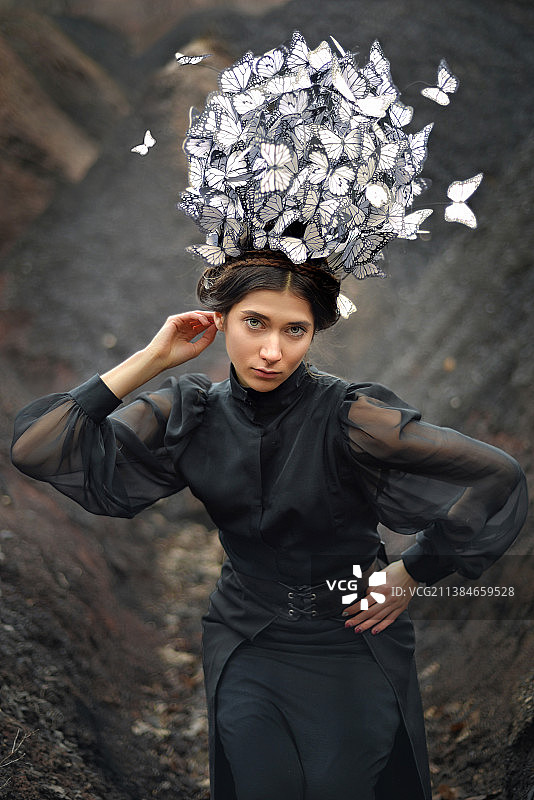 头戴蝴蝶帽站在墙边的年轻女子肖像，乌克兰图片素材