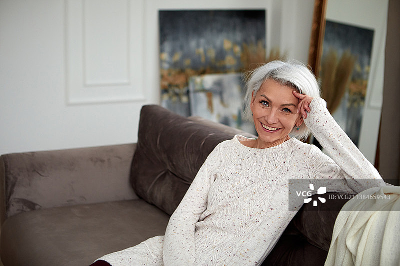 坐在沙发上的银发时尚女人图片素材