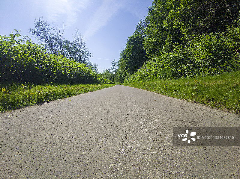 德国埃森天空下的树木旁的空旷道路图片素材