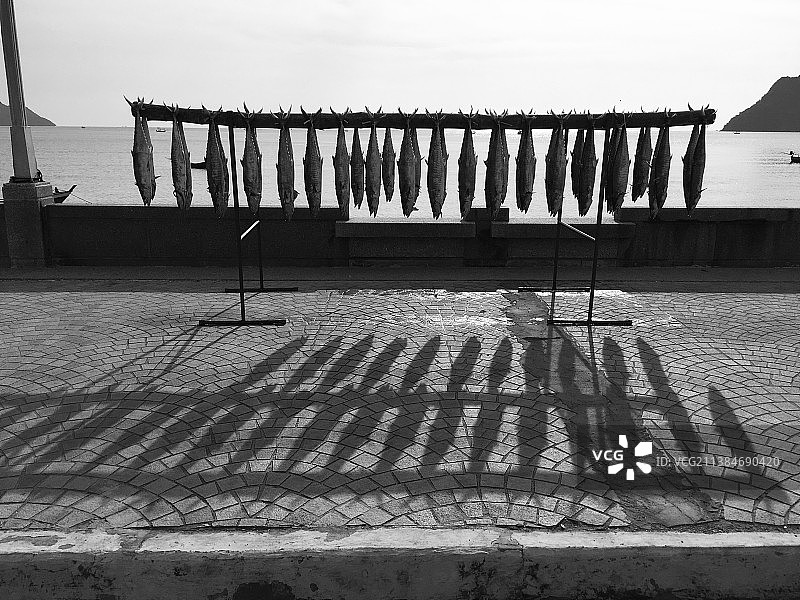 海滩上的鱼干和空的长椅图片素材