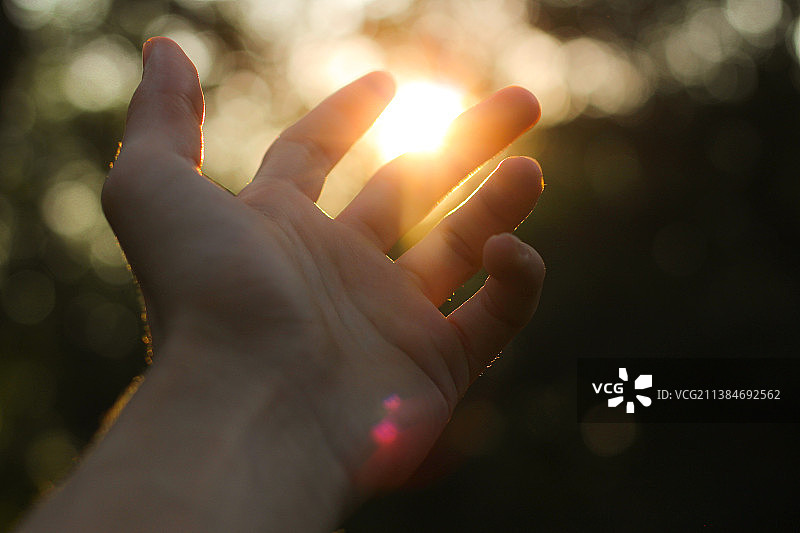 日落时天空下人手的特写图片素材