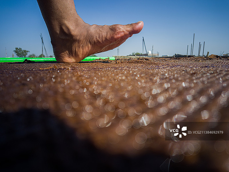 海滩上站在沙滩上的男人腿部照片图片素材