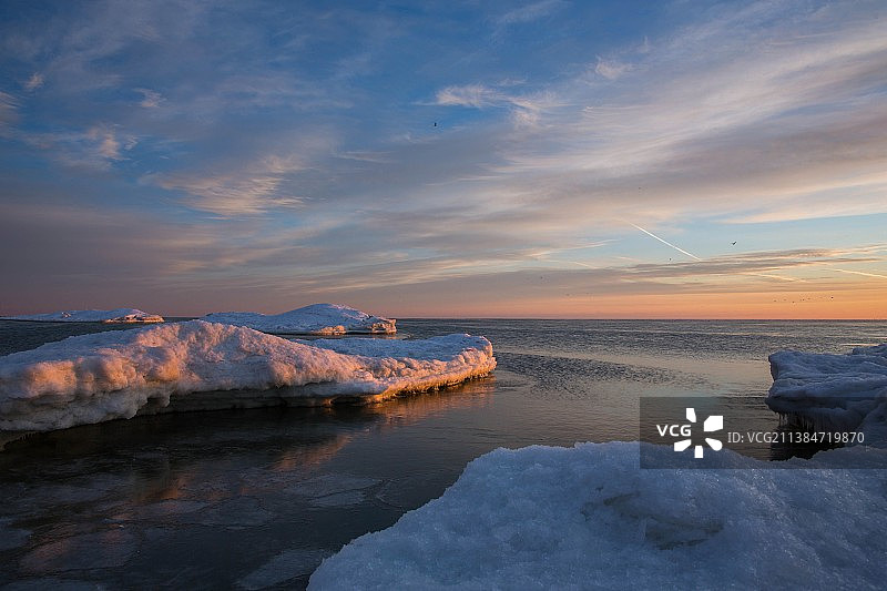 夕阳下的海景，加拿大皮利角国家公园，阳光洒在雪上图片素材