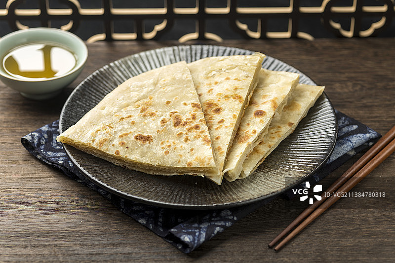 一盘烙饼大饼摆放在木桌面上特写图片素材