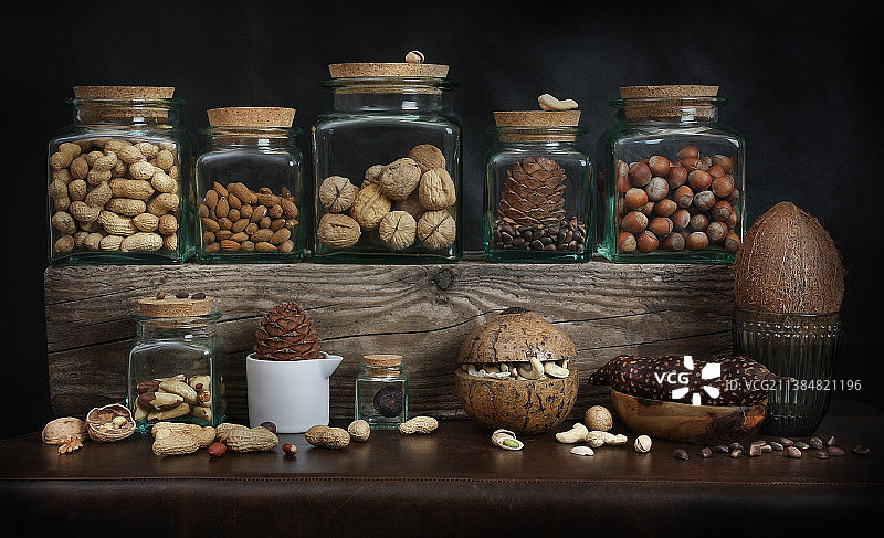黑色背景下，桌子上罐子里的各种食物特写图片素材