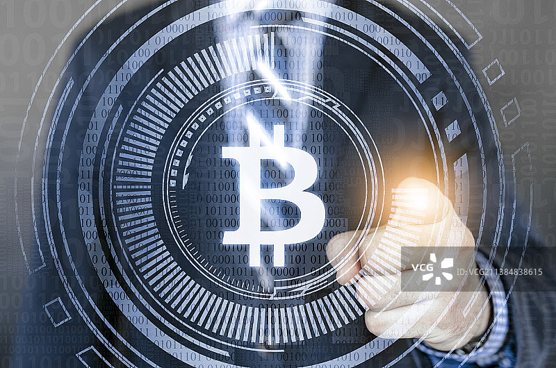 男性商务人士用手指触摸屏幕上显示的比特币图片素材