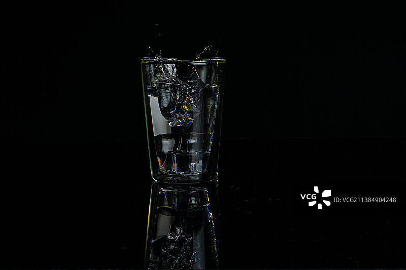 玻璃杯中的水特写，黑色背景图片素材