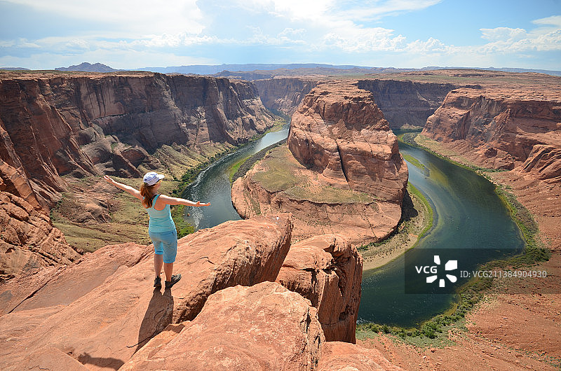 站在美国亚利桑那州科科尼诺县岩石上欣赏壮丽景色的女人图片素材