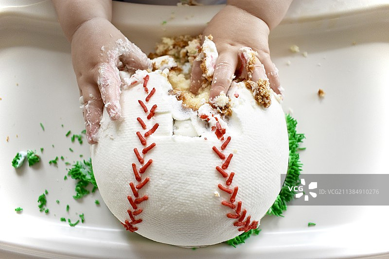 宝宝在盘子里拿着面团的棒球蛋糕图片素材