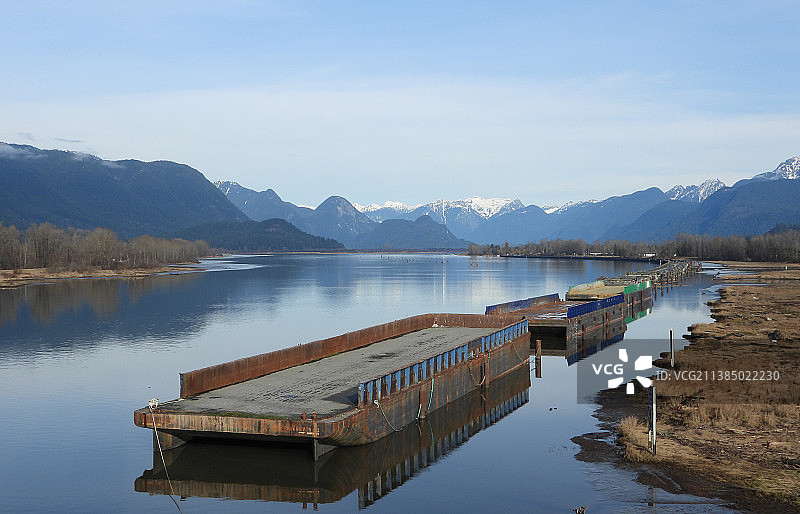 停泊在加拿大不列颠哥伦比亚省宁静河流上的驳船图片素材