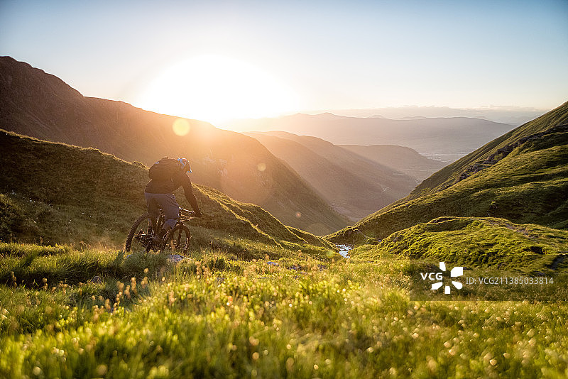 最后一缕阳光，山地自行车骑行者在山顶，英国高地图片素材