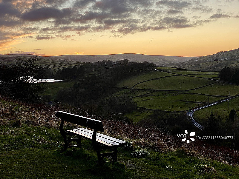 日落时分，空旷的田野长椅与天空相映成辉图片素材
