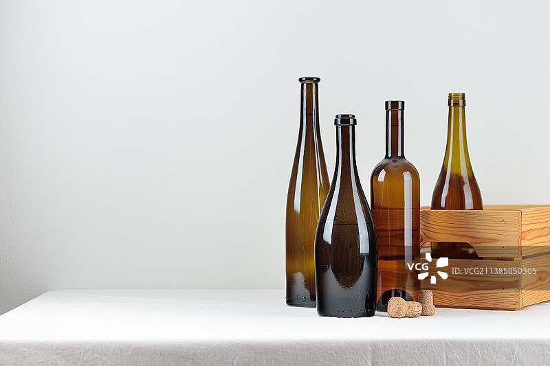 白色桌子上盒子里的绿色酒瓶图片素材