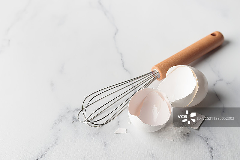 大理石上的线圈打蛋器和蛋壳（高角度）图片素材