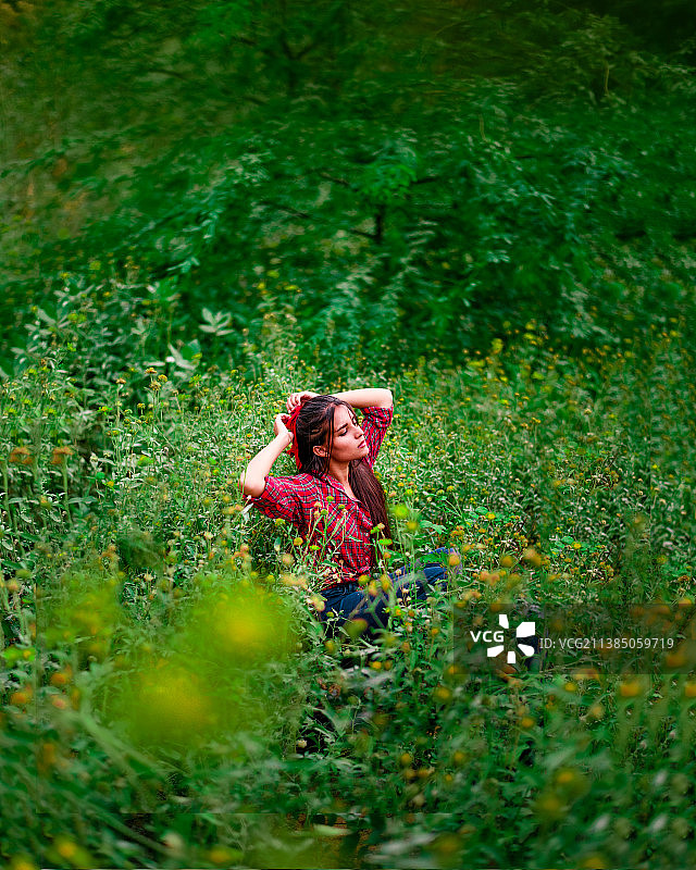 在印度森林的植物中，戴着红色发带的女人图片素材