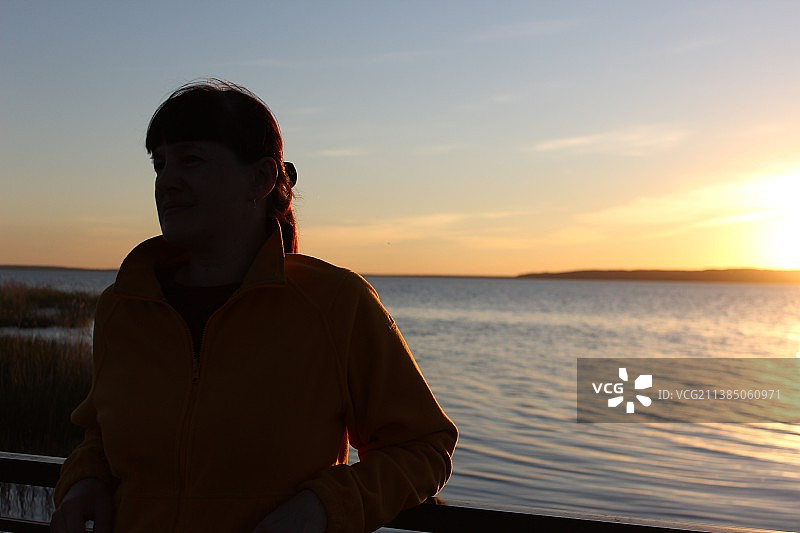 女孩和日落，男人在日落时看着天空中的大海图片素材