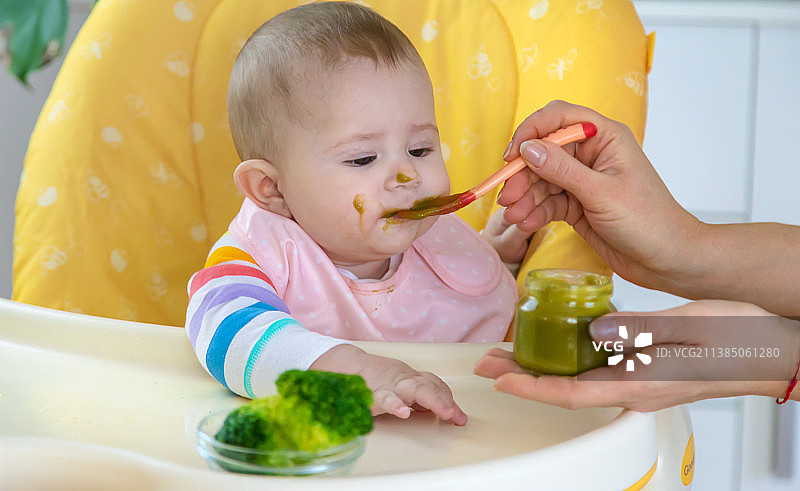 正在吃西兰花蔬菜泥的小宝宝，选择性聚焦图片素材