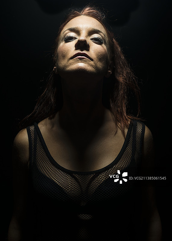 黑色背景下年轻女人特写肖像图片素材