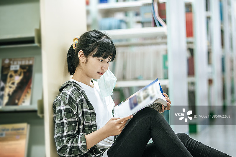 女人坐在图书馆里看书图片素材