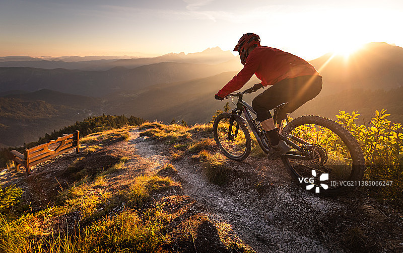 日落时分男子在小路上骑山地自行车图片素材