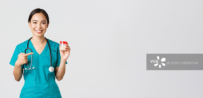 身穿医疗装备的年轻亚洲女医务工作者肖像，白色背景图片素材