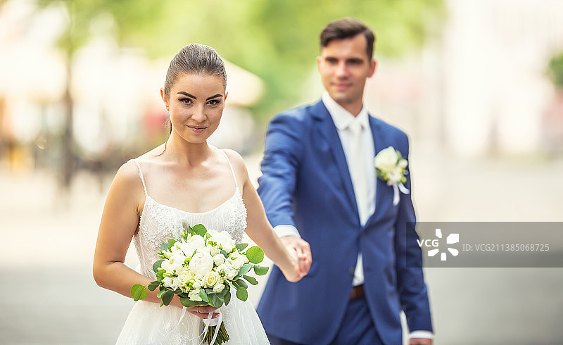 一对迷人的夫妇在小镇里手牵着手散步图片素材