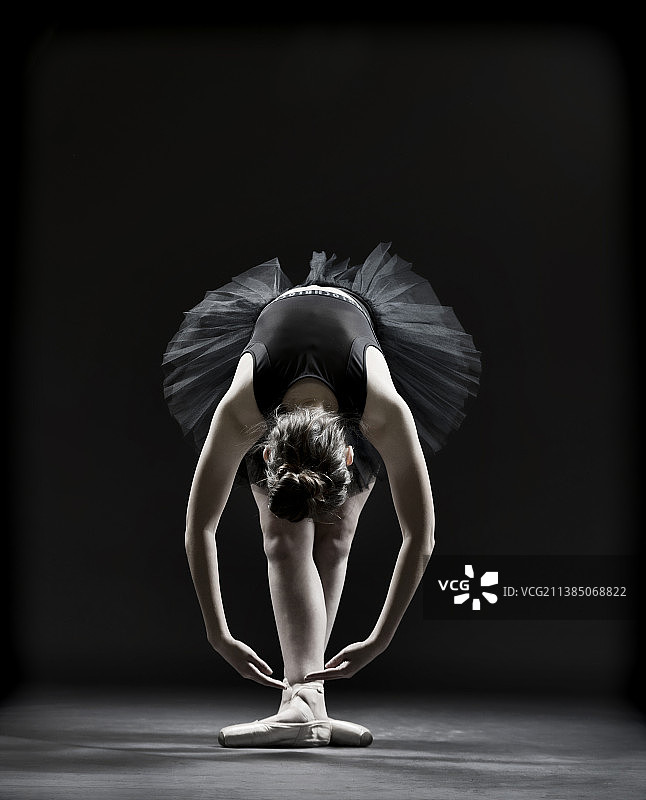年轻舞者在黑色背景的舞台上表演图片素材