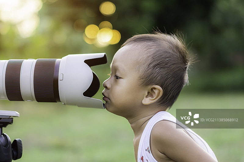 男孩用相机拍照的侧面视角图片素材