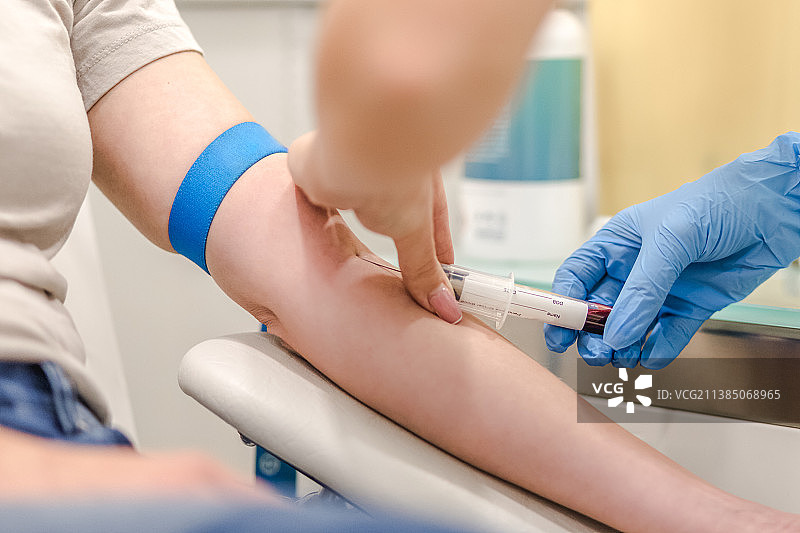医院里医生从病人手臂上抽取血样特写图片素材