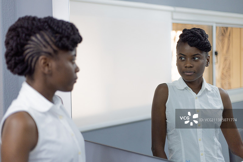 站在办公室看着倒影的自信商务人士肖像，罗安达，安哥拉图片素材