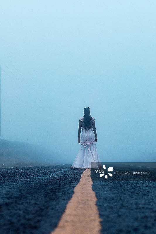 寒冷多雾的早晨：女子站在肯尼亚基安布雾中的背影图片素材