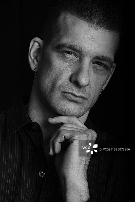 非常严肃，年轻男子黑色背景特写肖像图片素材