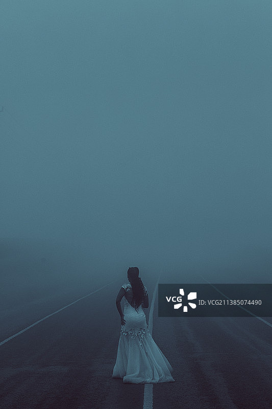 寒冷多雾的早晨：女子站在肯尼亚基安布雾中的背影图片素材