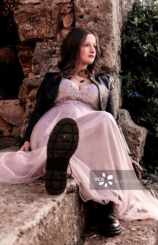 年轻女子靠在石墙上图片素材