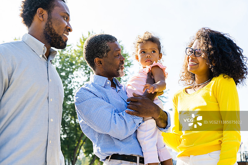 快乐的非裔美国家庭在公园里互动图片素材
