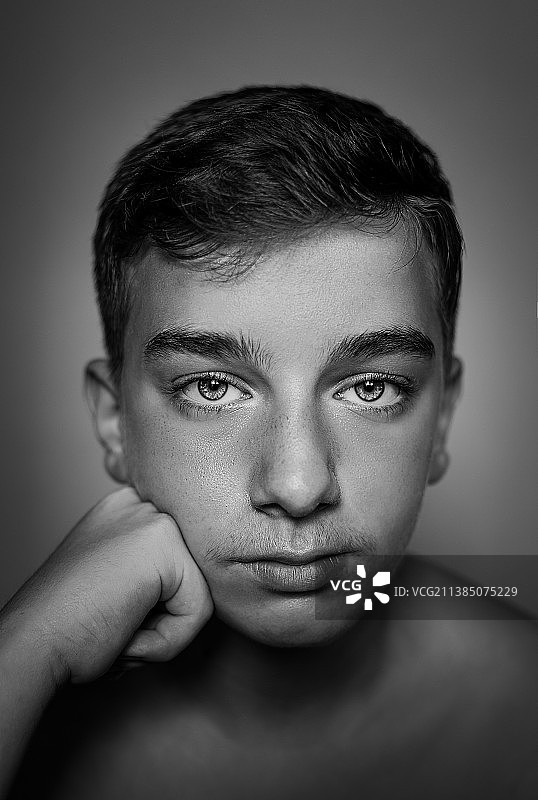 灰色背景下，未穿上衣男孩的特写图片素材